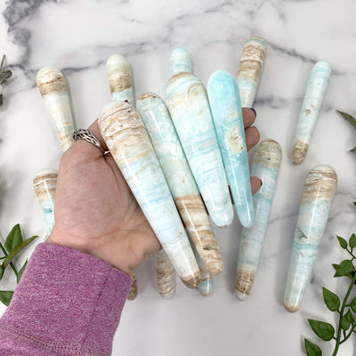 4 wands in hand with marble background