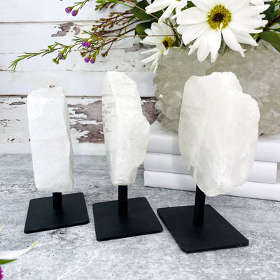 3 Polished Crystal Quartz Stone on Metal Stand from a side view to show thickness 