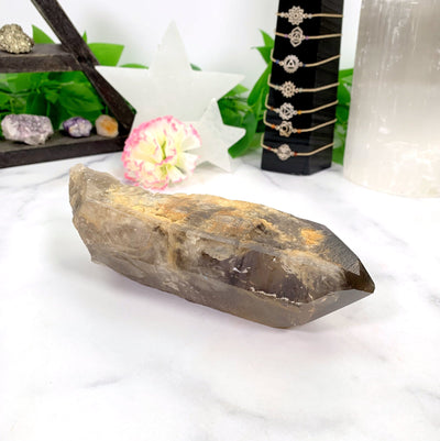 Natural Smoky Lemurian Quartz Point - laying on a table