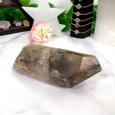 Natural Smoky Lemurian Quartz Point - laying on a table