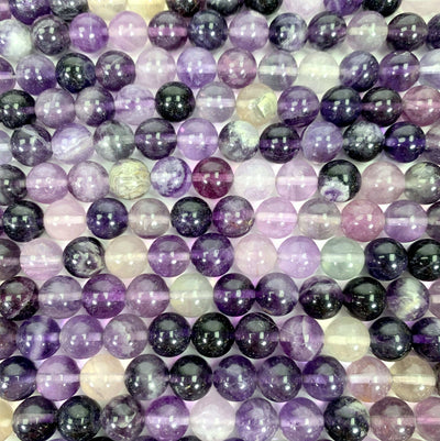 purple fluorite beads laid out on a white background