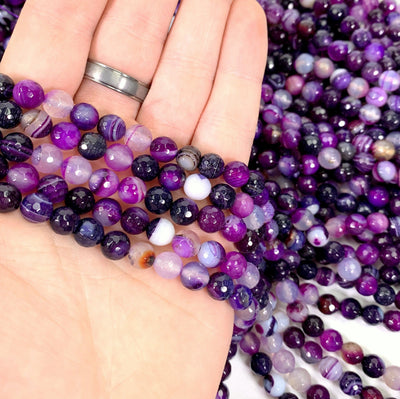 dyed purple agate beads in hand