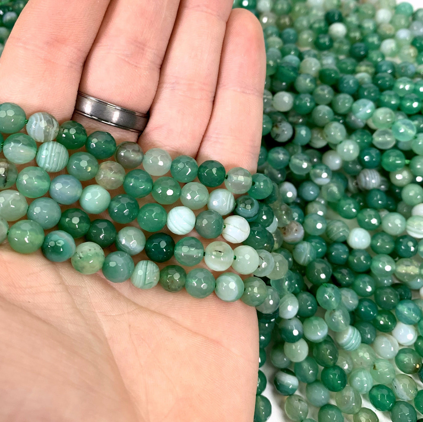 dyed green agate beads in hand