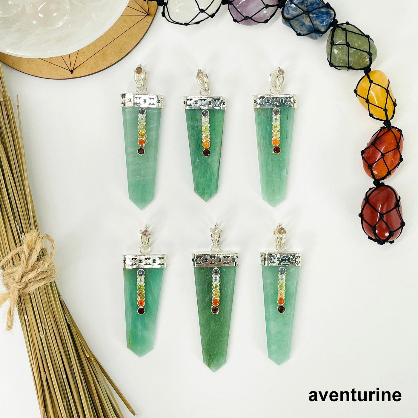 overhead view of six aventurine polished point pendants with chakra gemstone accent for possible variations