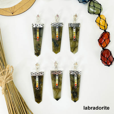 overhead view of six labradorite polished point pendants with chakra gemstone accent for possible variations