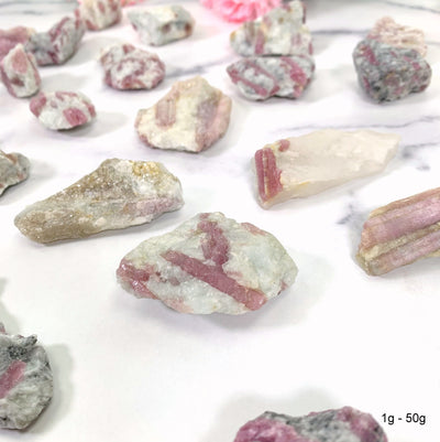atural Pink Tourmaline with Mica on Matrix - scattered on a table