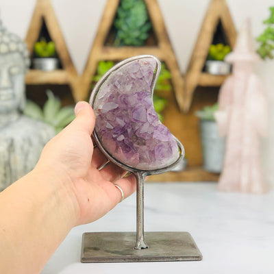 Amethyst moon cluster in a silver metal base with metal surrounding the moon.  