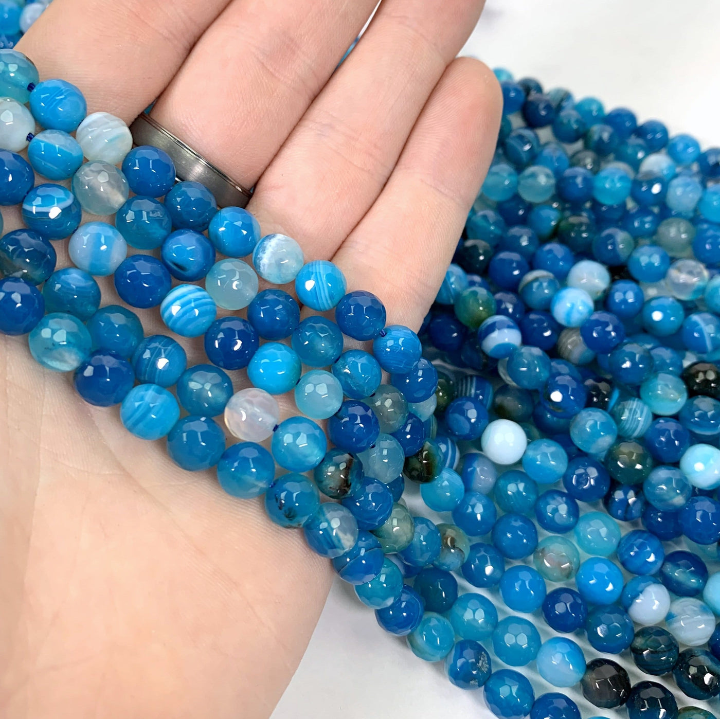 dyed blue agate beads in hand