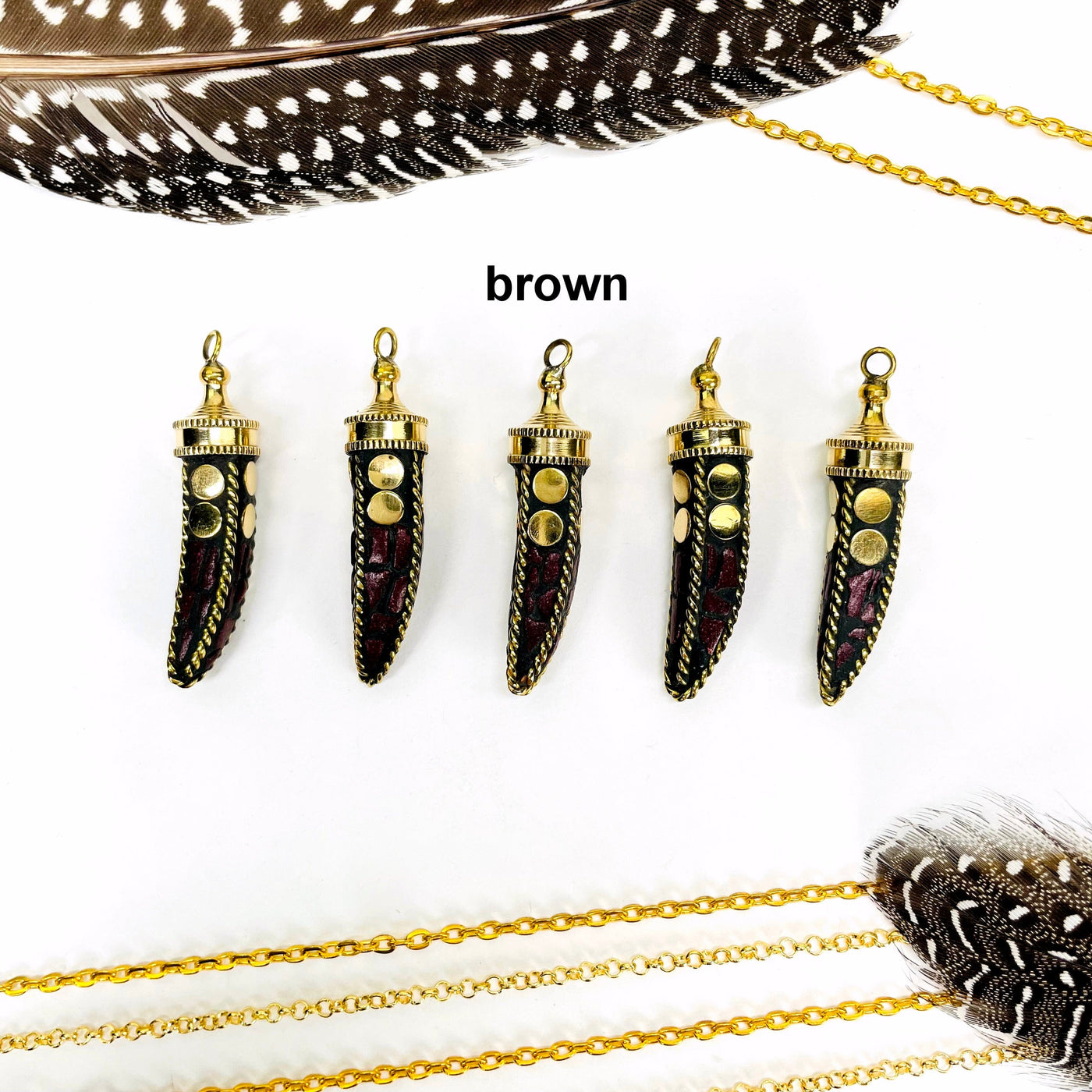 overhead view of five brown petite mosaic horn pendants in a row on white background with decorations for possible variations