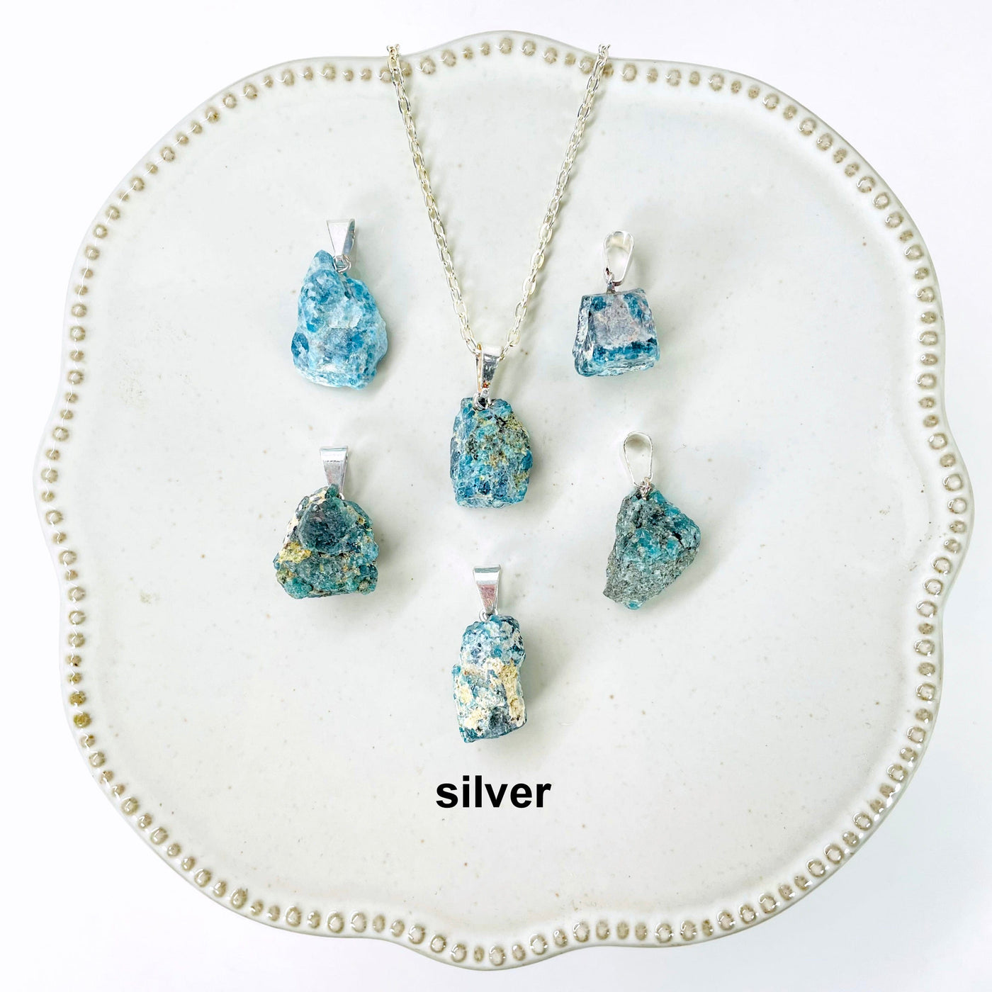 six silver raw blue apatite chunk pendants on display for possible variations