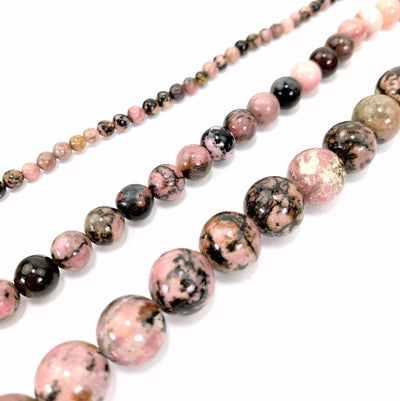 all 3 variations of rhodonite laid out on a white background