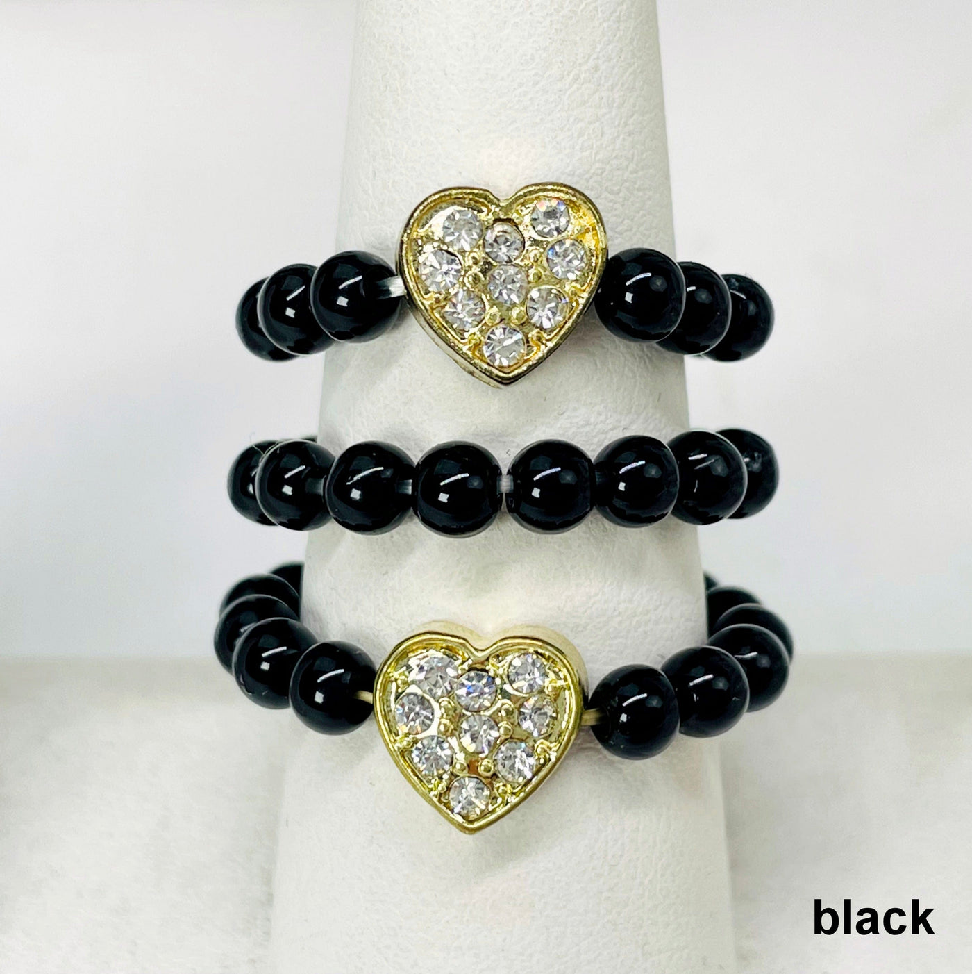 close up of three black heart elastic rings on ring display