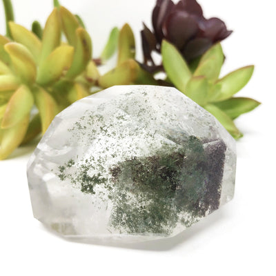 Crystal Quartz Cut and Polished Freeform Stone with Chlorite Inclusions with decorations in the background