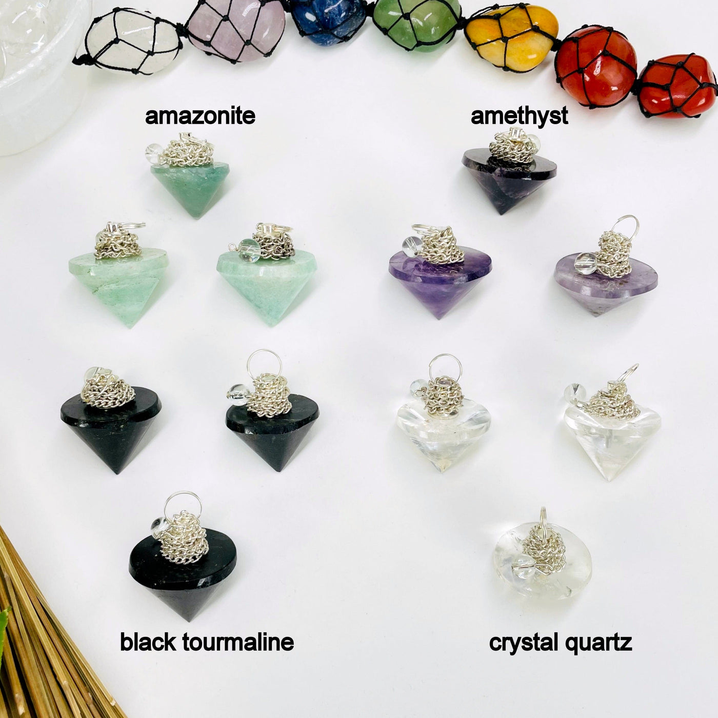 three amazonite, amethyst, black tourmaline, and crystal quartz pendulum pendants on white background for possible variations