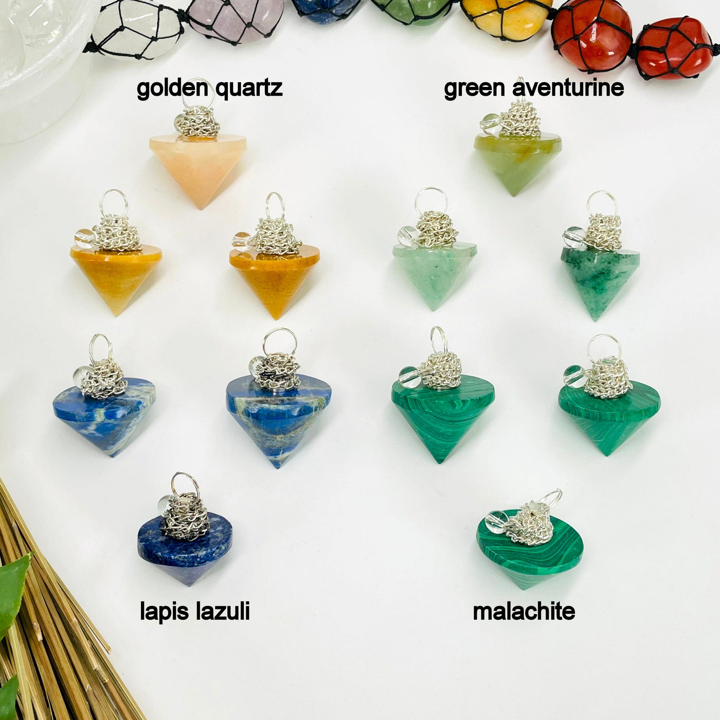 three golden quartz, green aventurine, lapis lazuli, and malachite pendulum pendants on white background for possible variations