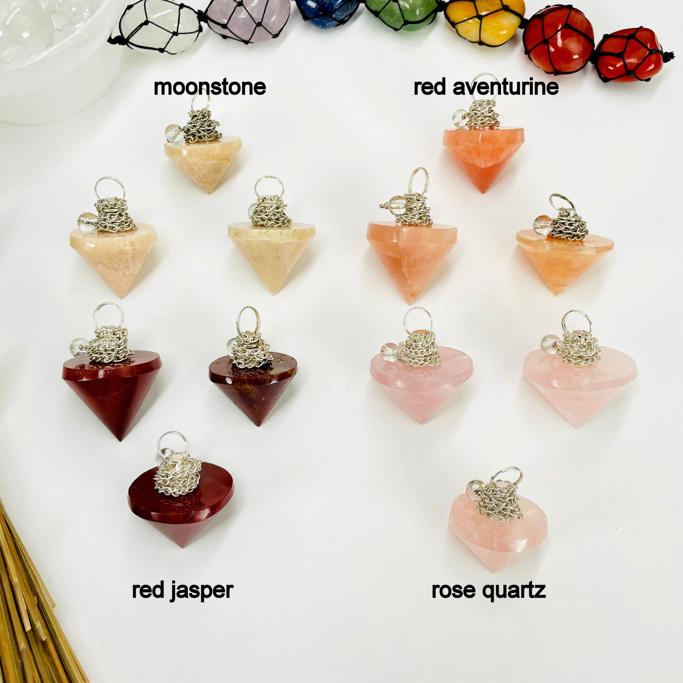 three moonstone, red aventurine, red jasper, and rose quartz pendulum pendants on white background for possible variations