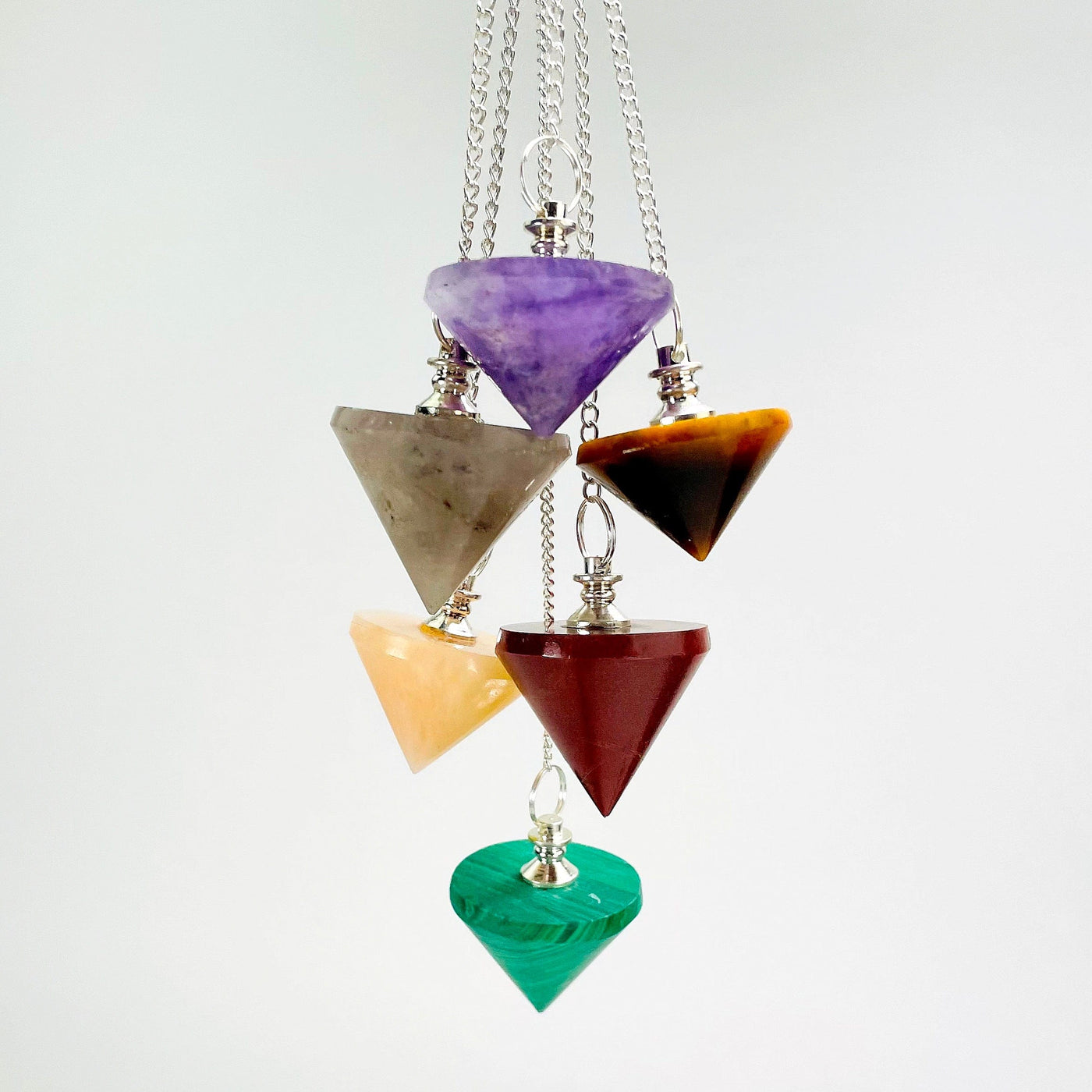 six different pendulum pendants hanging in front of white background