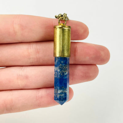 close up of tier 2 lapis lazuli point pendant in hand for size reference and details