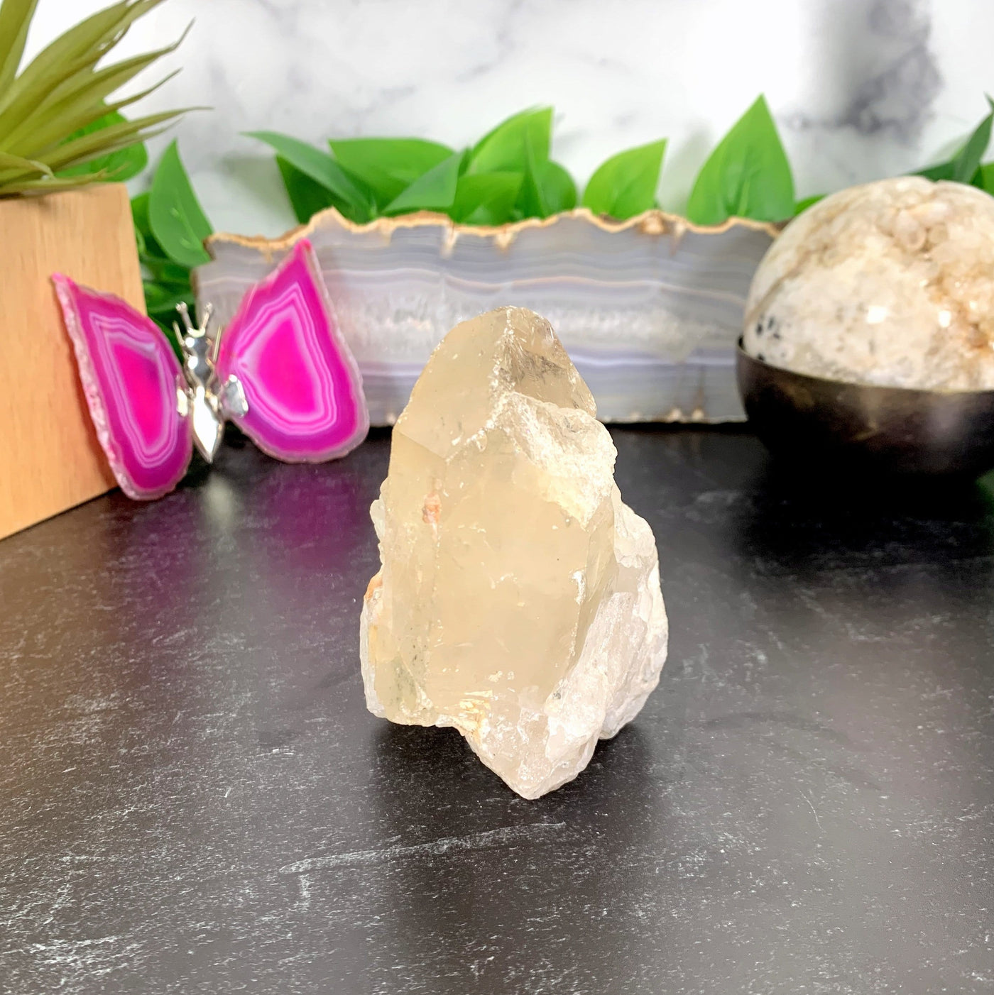 A one of a kind piece of a tangerine quartz cluster on a table