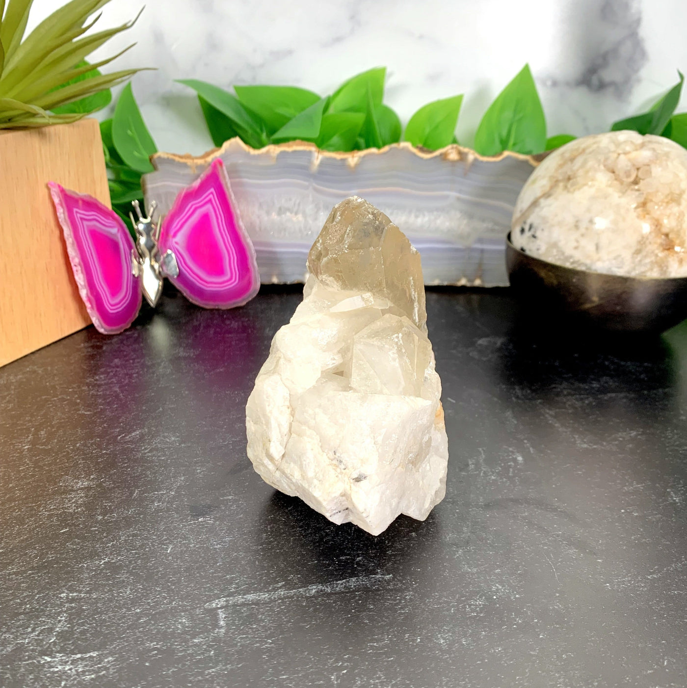 A one of a kind piece of a tangerine quartz cluster on a table