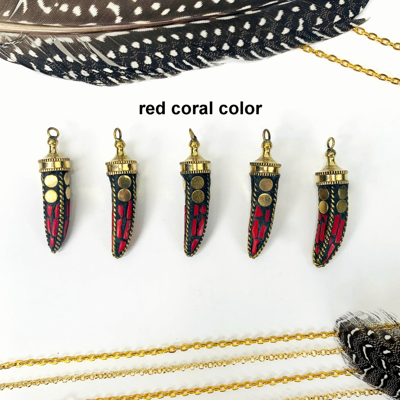 overhead view of five red coral color petite mosaic horn pendants in a row on white background with decorations for possible variations
