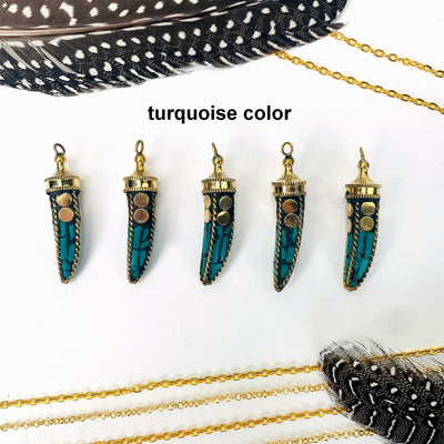 overhead view of five turquoise color petite mosaic horn pendants in a row on white background with decorations for possible variations