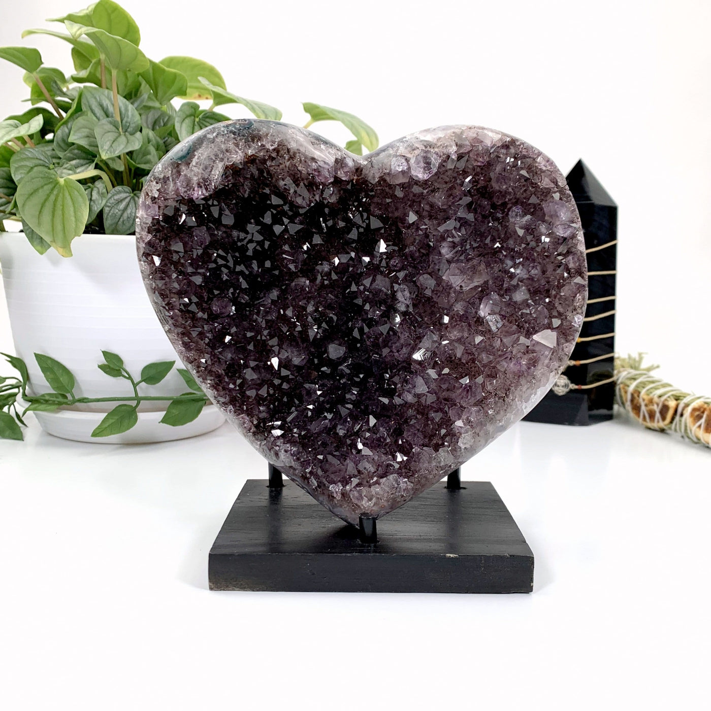 Dark Amethyst Druzy Heart Semi-Polished in Wood Stand on White Background.