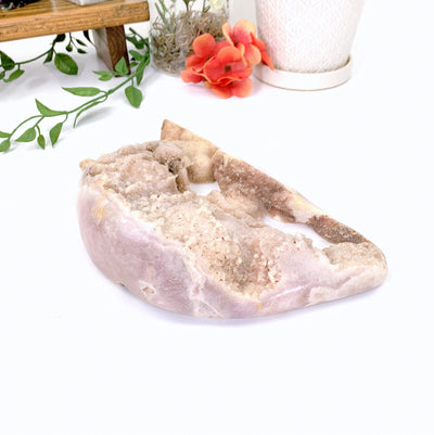 Pink Amethyst Druzy Formation with decorations in the background