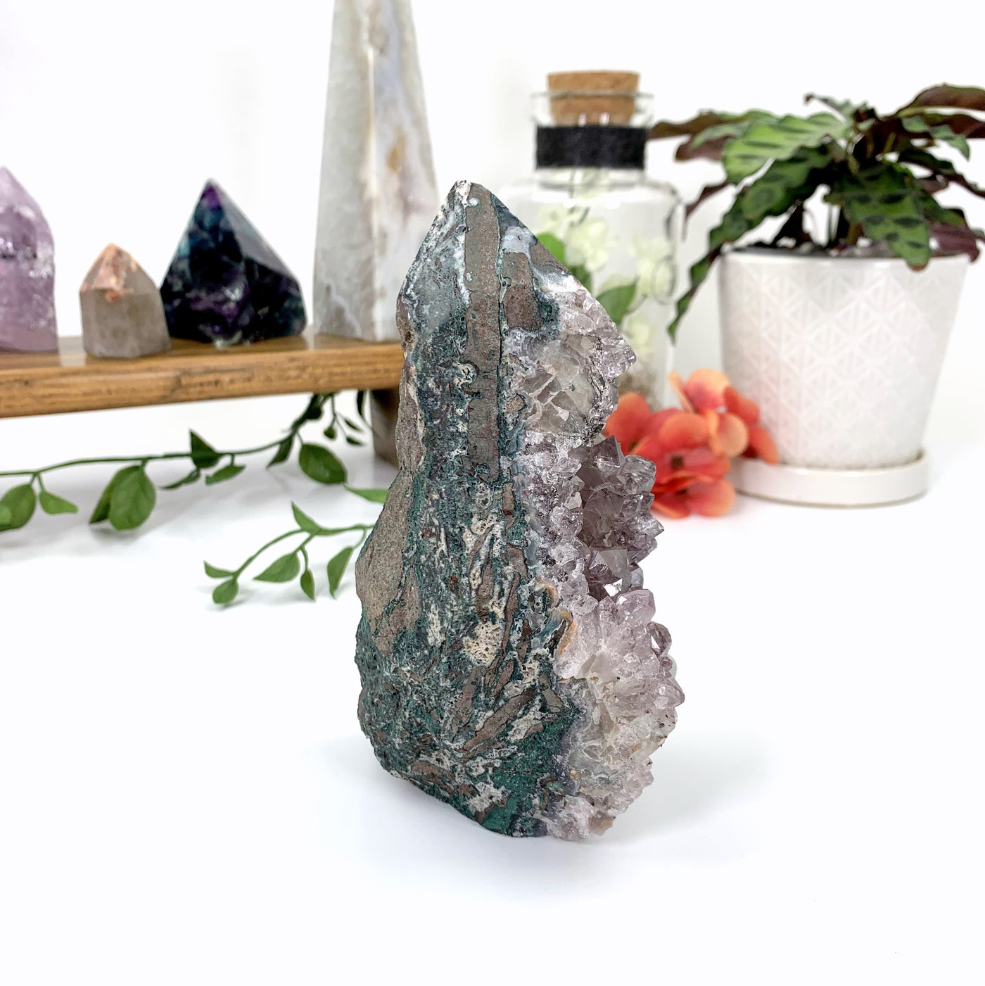 Amethyst cluster with a polished top to make it a point.  Flat at the bottom so it can stand on it's own.  Side view showing it is gray and green basalt on the side.