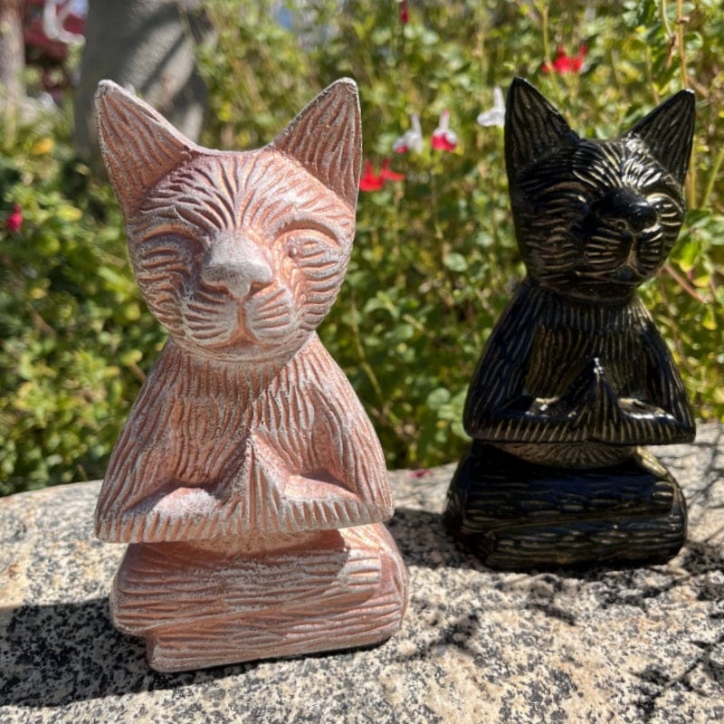 white and black cat buddha statues displayed as home decor 