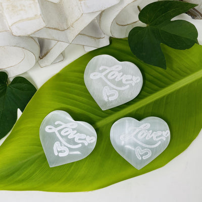 overhead view of selenite engraved "love" heart stones for details and possible variations