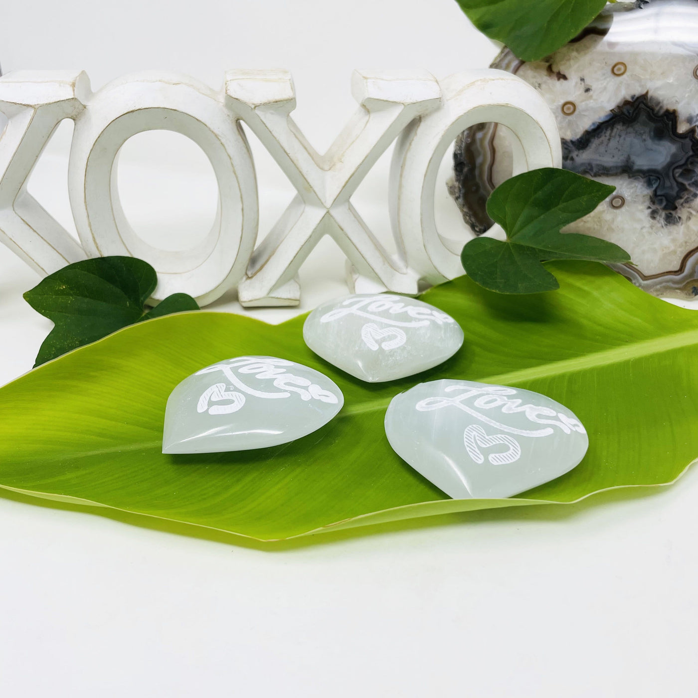 side view of selenite engraved "love" heart stones for thickness