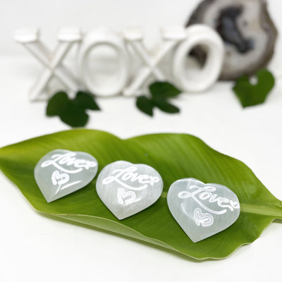 selenite engraved "love" heart stones on display