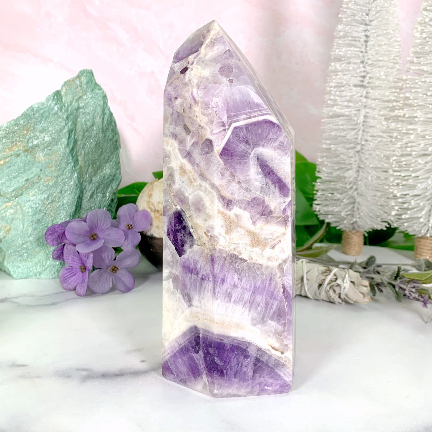Chevron Amethyst Polished Tower with decorations in the background