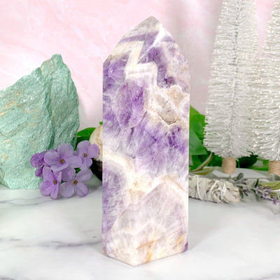 Chevron Amethyst Polished Tower with decorations in the background