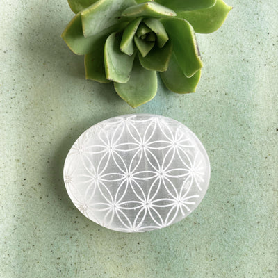 close up of selenite flower of life engraved palm stone for engraving details