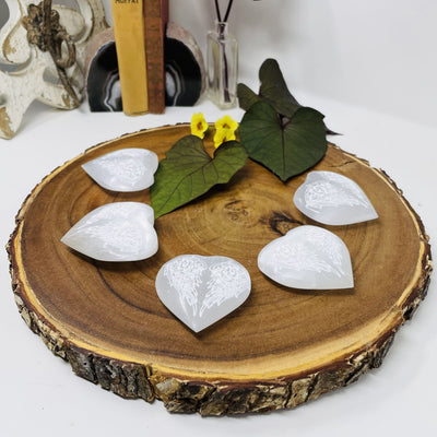 Selenite Stone Heart - Selenite Hearts with Angel Wing Engraving on a wood plate showing side view