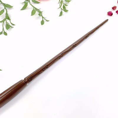 Up close shot of tip of Enchantment Wand with plants on white background