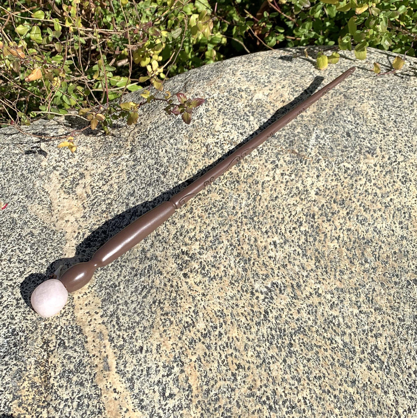 Enchantment Wand on a rock outside next to a bush