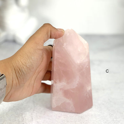 Hand comparing size to Option C - Rose Quartz  Semi Polished Points Tower