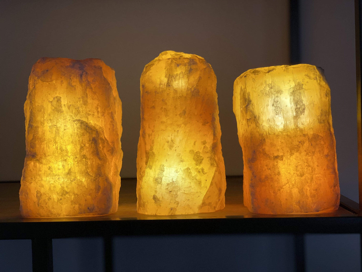 3 Rough Stone Lamps lit up in a dark room