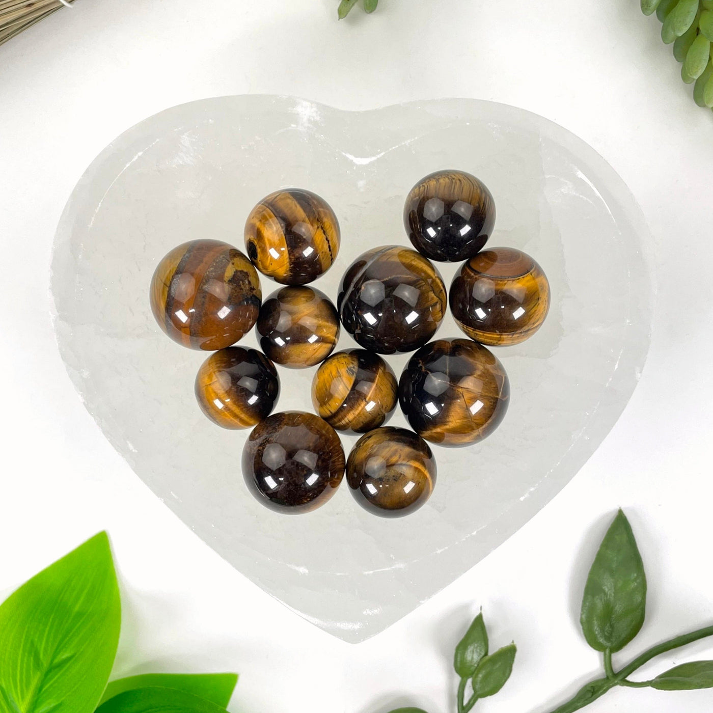 close up of many tigers eye spheres in a heart bowl for details and possible variations