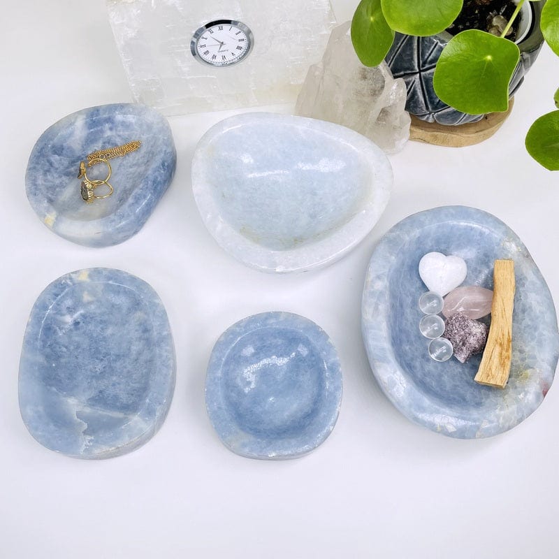 multiple blue calcite bowls displayed to show the differences in the sizes and color shades