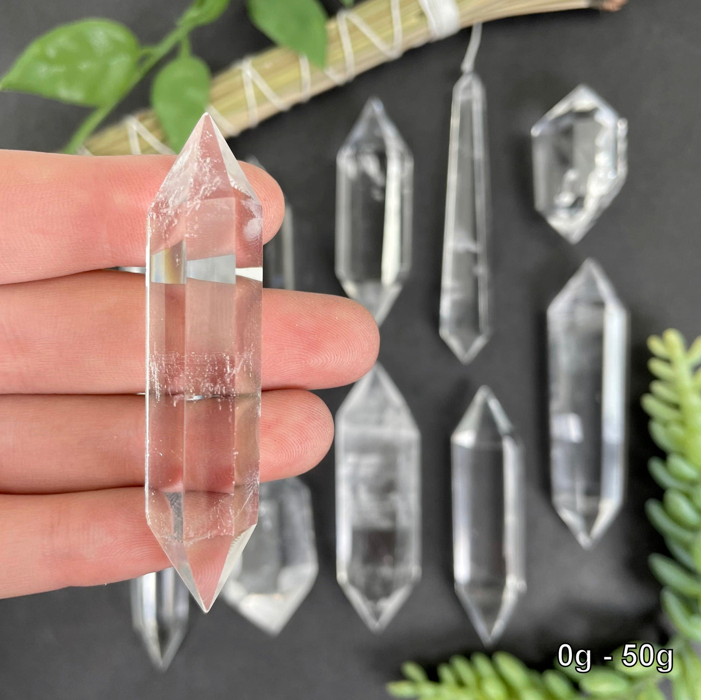 close up of one 0g - 50g crystal quartz point for size reference and details with many others in background