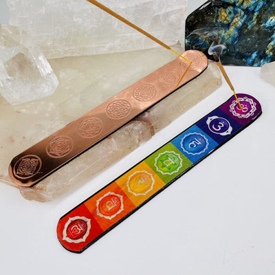copper toned and colorful seven chakras themed incense stick burners displayed as home decor 
