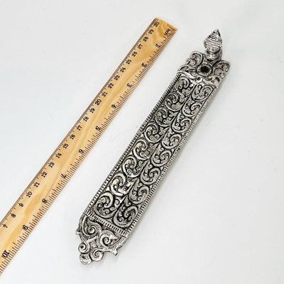 incense holder next to a ruler for size reference 