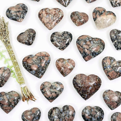 multiple rhyolite hearts showing different patterns and sizes on a white background 