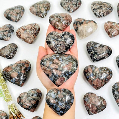 rhyolite hearts in hand showing different sizes 
