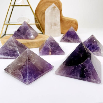 multiple amethyst pyramids displayed to show the differences in the sizes and color shades 
