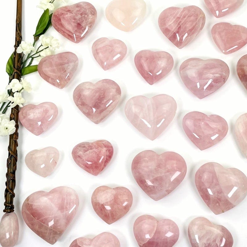 multiple rose quartz hearts showing the different shades and sizes  on white background 